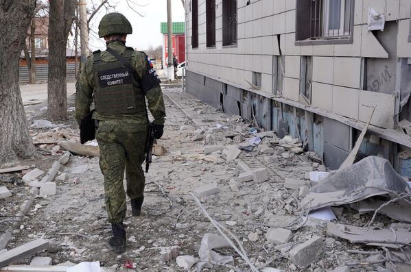 Сотрудник следственного комитета России фиксирует последствия обстрела украинскими войсками Волновахи из РСЗО HIMARS