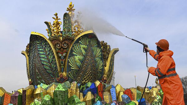 Работник моет скульптурную композицию фонтана Каменный цветок на ВДНХ