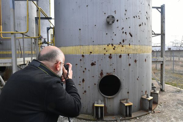 Журналист фотографирует повреждения от обстрелов на территории Запорожской АЭС в Энергодаре