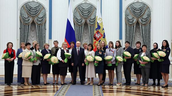 Президент РФ Владимир Путин фотографируется с участницами церемонии вручения государственных наград по случаю Международного женского дня