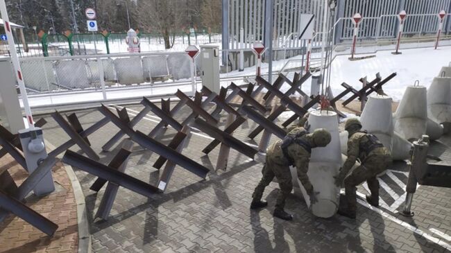 Польские военные расставляют противотанковые ежи на дорогах, ведущих из Белоруссии