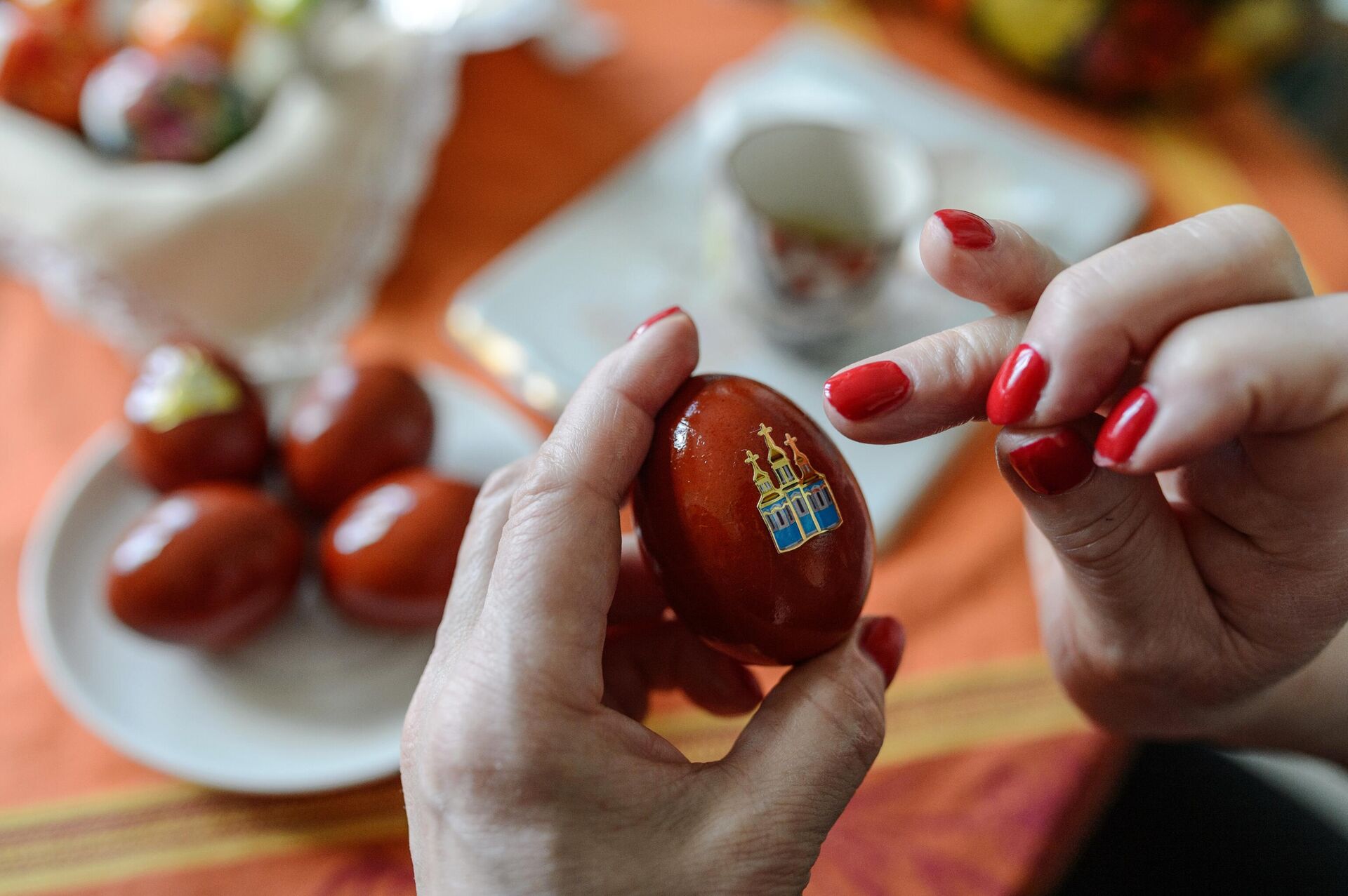 Женщина украшает пасхальные яйца наклейкой к празднику Святой Пасхи - РИА Новости, 1920, 10.03.2023