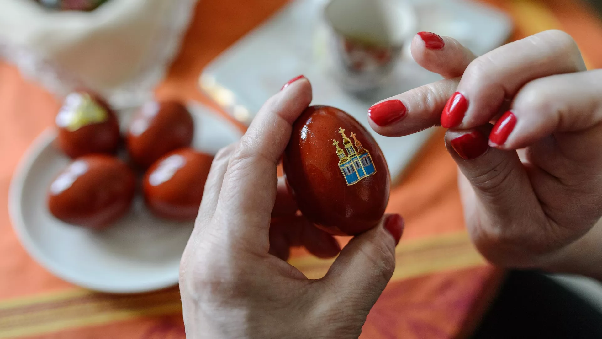 Женщина украшает пасхальные яйца наклейкой к празднику Святой Пасхи - РИА Новости, 1920, 25.04.2024