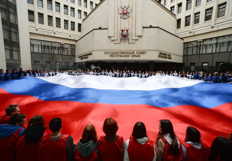 Участники акции, посвященной Дню воссоединения Крыма с Россией, на площадке перед Госсоветом Республики Крым