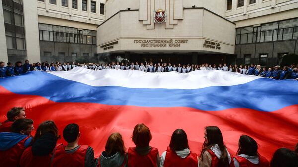 Участники акции, посвященной Дню воссоединения Крыма с Россией, на площадке перед Госсоветом Республики Крым
