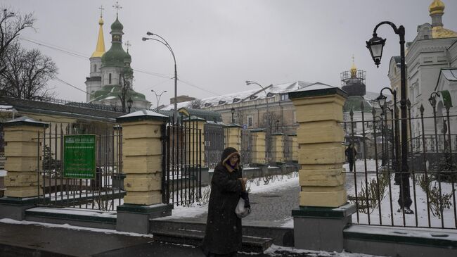 Женщина проходит мимо Киево-Печерской лавры в Киеве