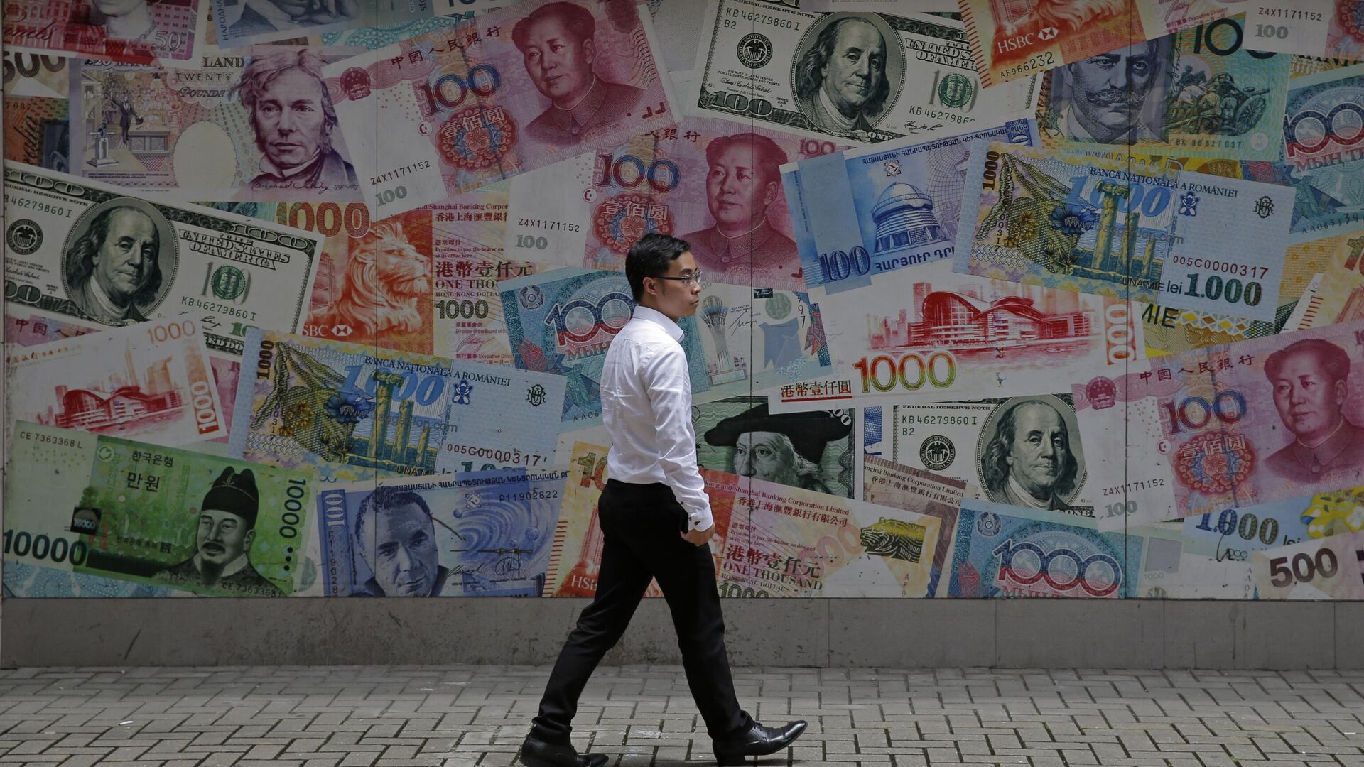Мужчина проходит мимо пункта обмена валюты в Гонконге - РИА Новости, 1920, 26.04.2023