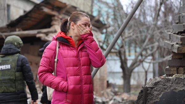 Женщина возле своего дома, поврежденного в результате обстрела Донецка со стороны ВСУ