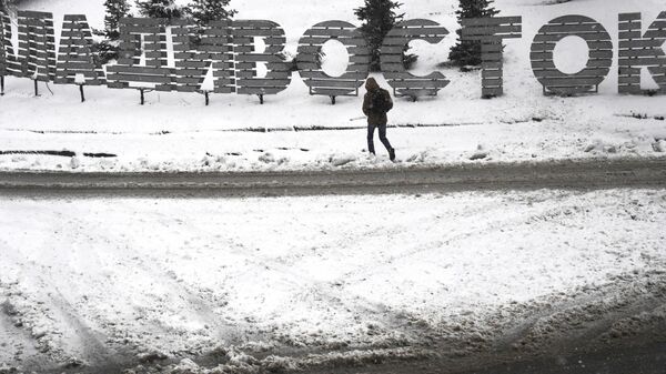 Мужчина переходит дорогу на одной из улиц Владивостока