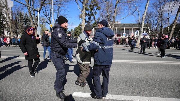 Police officers detain a person who participated in an opposition protest in the center of Chisinau