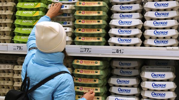 Покупательница выбирает упаковку с яйцами в гипермаркете Ашан в Москве