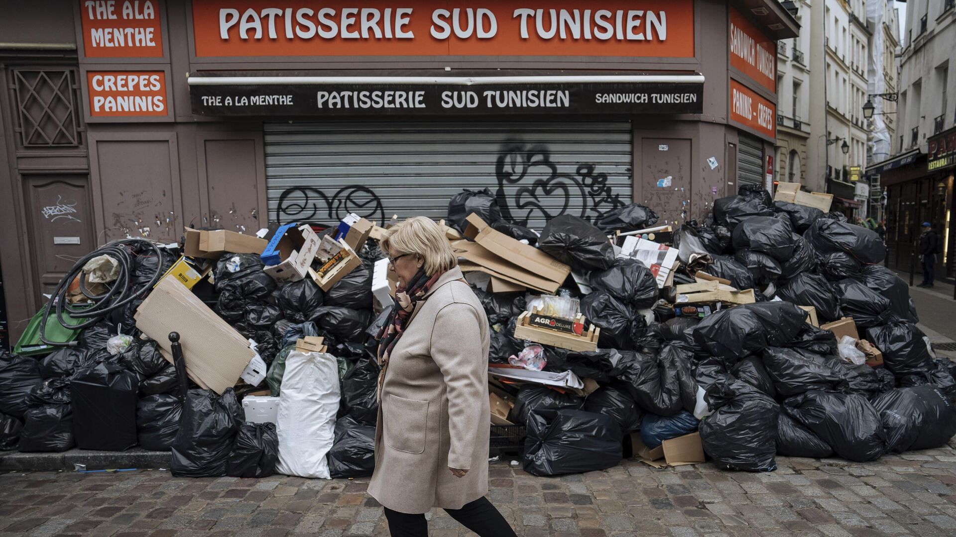 Женщина проходит мимо неубранного мусора в Париже, Франция. 13 марта 2023 - РИА Новости, 1920, 13.03.2023