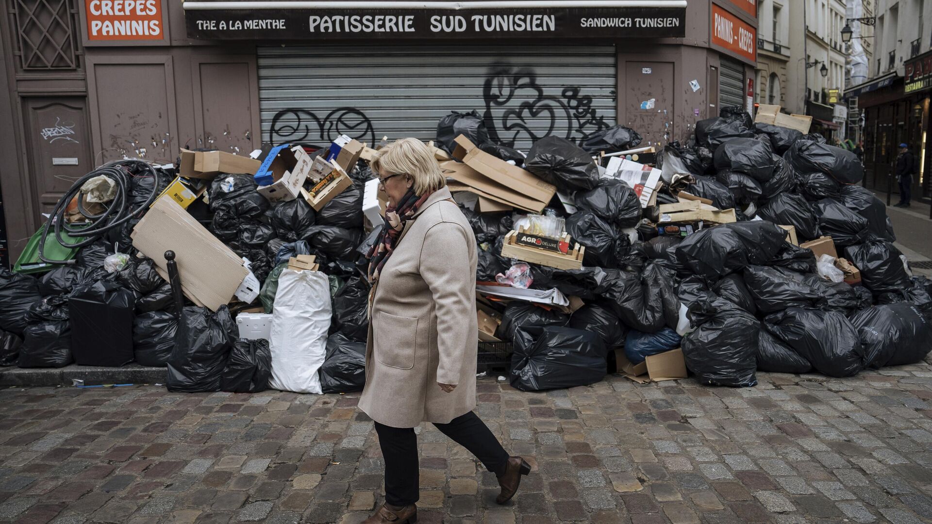 Женщина проходит мимо неубранного мусора в Париже, Франция. 13 марта 2023 - РИА Новости, 1920, 13.03.2023