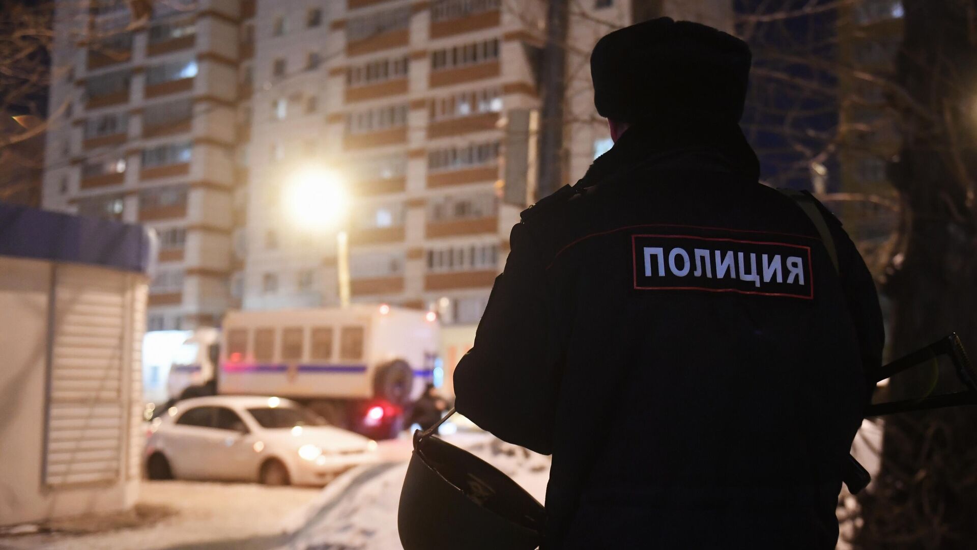 Сотрудник правоохранительных органов у одного из жилых домов - РИА Новости, 1920, 23.12.2025