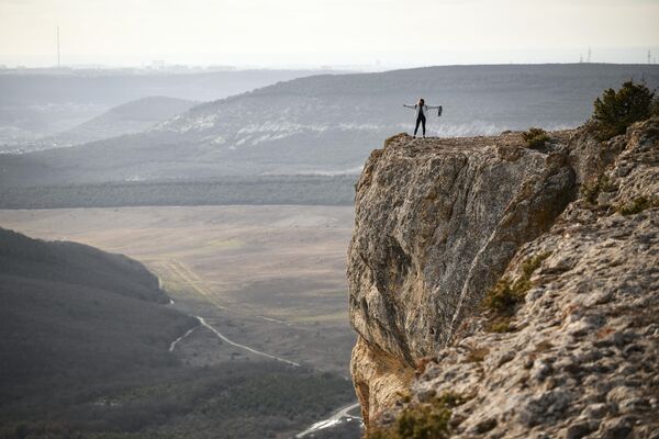 Девушка на обрыве горы Челтер-Кая в Крыму, где находится пещерный монастырь Челтер-Мармара