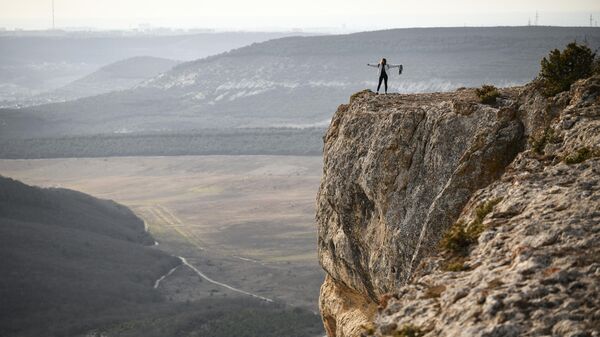 Девушка на обрыве горы Челтер-Кая в Крыму, где находится пещерный монастырь Челтер-Мармара