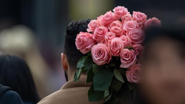 Мужчина с букетом цветов в международный женский день