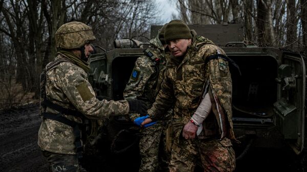 Медики эвакуируют раненого украинского солдата под Артемовском
