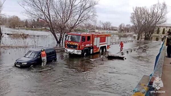 Спасение двух мужчин, чей автомобиль застрял на затопленном мосту через реку в ЛНР. Кадр из видео