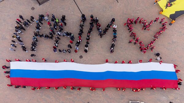 Участники акции, посвященной Дню воссоединения Крыма с Россией, на площади у Собора Андрея Первозданного в Геленджике