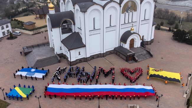 Участники акции, посвященной Дню воссоединения Крыма с Россией, на площади у собора Андрея Первозванного в Геленджике