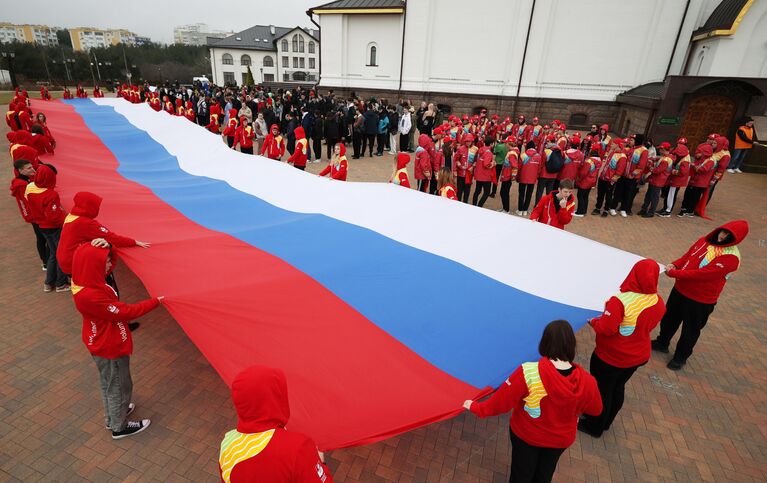 Участники акции, посвященной Дню воссоединения Крыма с Россией, на площади у Собора Андрея Первозданного в Геленджике