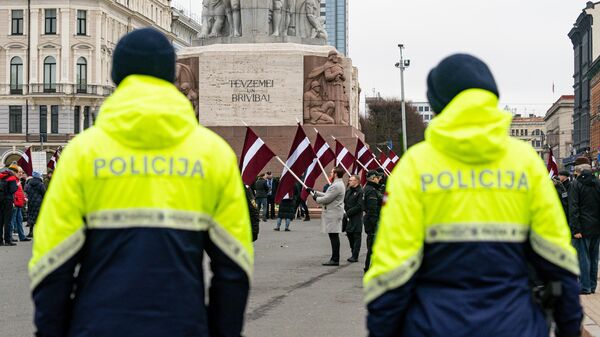 Полицейские и участники мероприятия у памятника Свободы в Риге, посвященного памяти Латышского добровольческого легиона СС