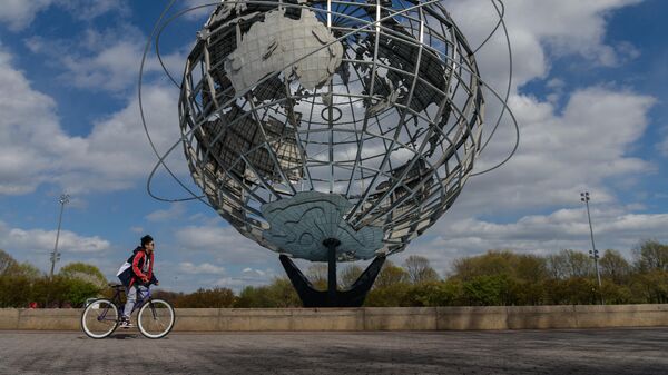 Мальчик проезжает на велосипеде мимо изображения Земли