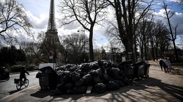 Люди проходят мимо неубранного мусора в Париже, Франция