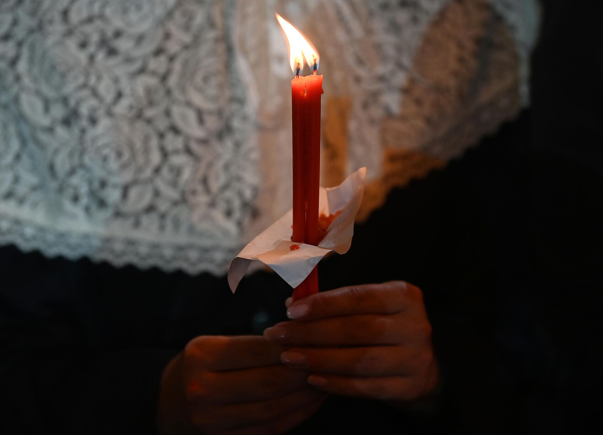 Свечи в руках прихожанки, присутствующей на пасхальном богослужении в храме Христа Спасителя в Москве - РИА Новости, 1920, 17.03.2023