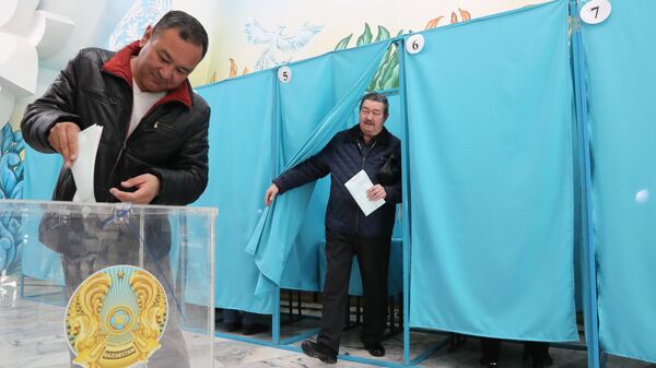Мужчина бросает в урну бюллетень на избирательном участке в Алма-Ате на внеочередных парламентских выборах в Казахстане.