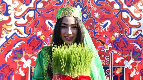Девушка держит в руках сэмэни - проросшую в тарелке пшеницу на праздновании Навруза в Казани