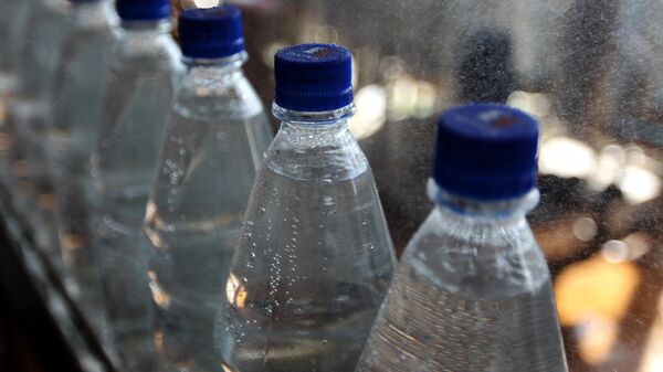 Бутылки с минеральной водой на транспортировочной ленте