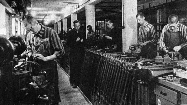 Заключенные работают на заводе по производству боеприпасов в концентрационном лагере Дахау