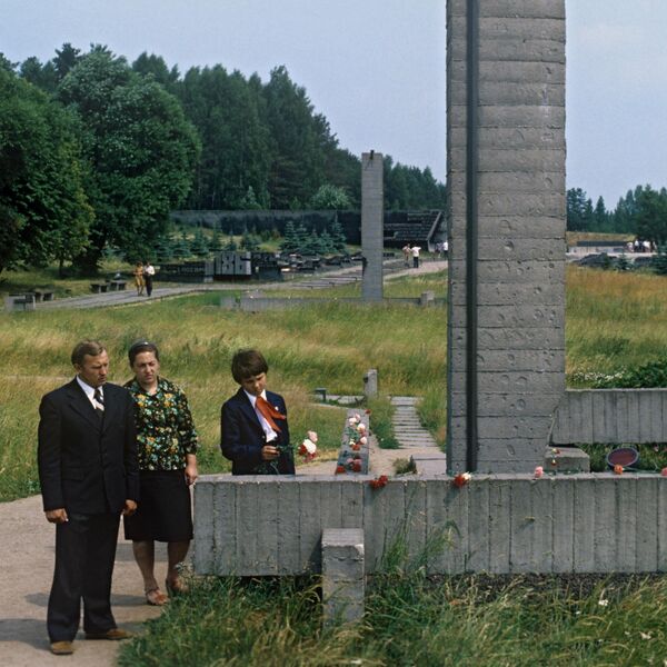 Мемориальный комплекс Хатынь, 1979 год, нижние венцы срубов домов и трубы-стелы с колоколами с бронзовыми табличками с именами тех, кто здесь родился и жил Мемориальный комплекс Хатынь, 1979 год, нижние венцы срубов домов и трубы-стелы с колоколами с бронзовыми табличками с именами тех, кто здесь родился и жил