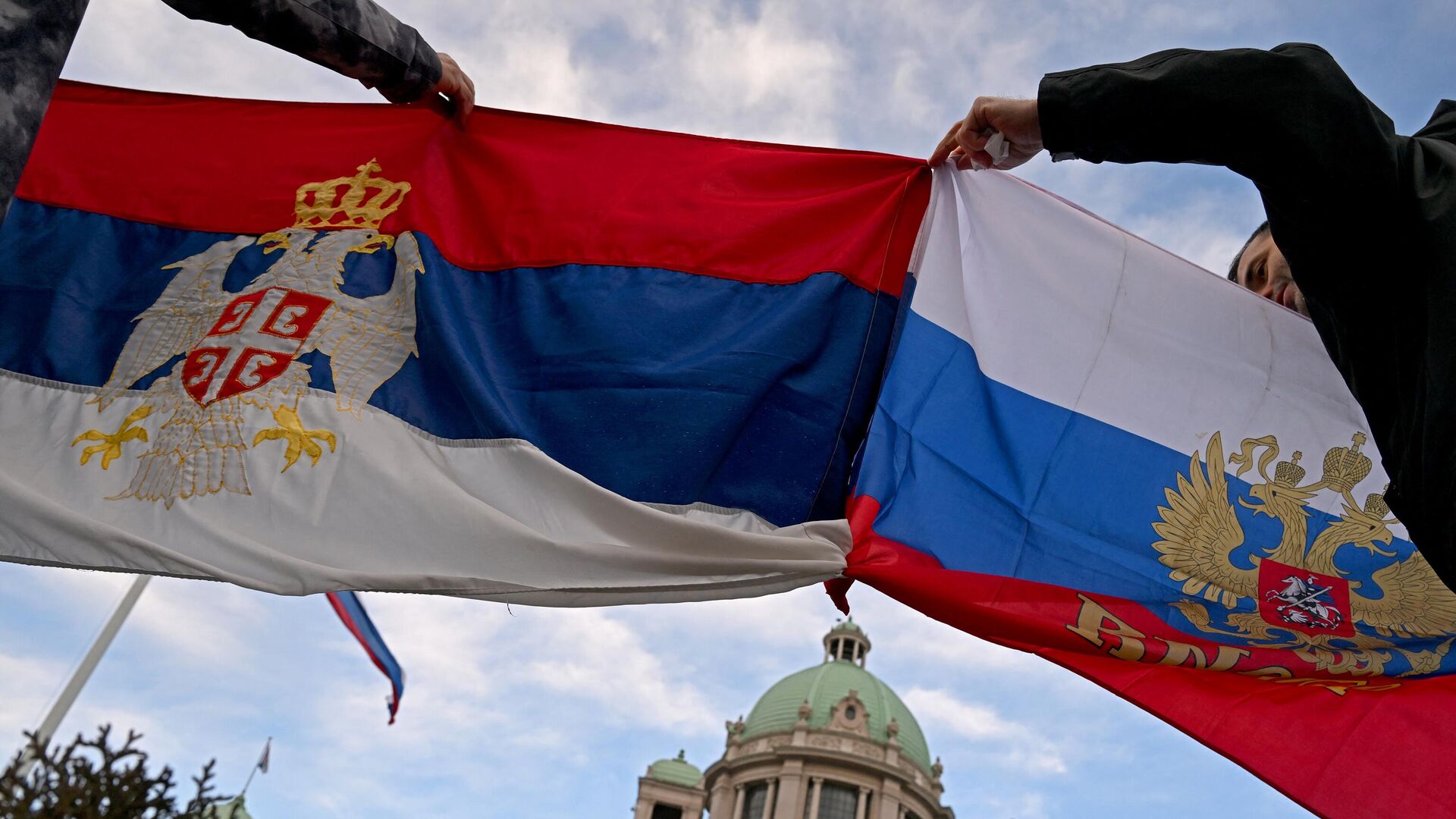 Люди держат флаги Сербии и России у здания Народной скупщины Сербии - РИА Новости, 1920, 21.03.2023