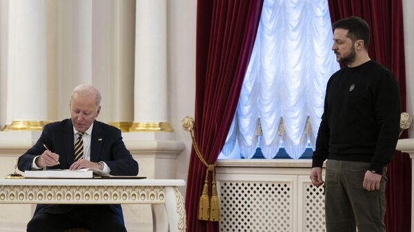 Президент Украины Владимир Зеленский наблюдает за тем, как президент Джо Байден подписывает гостевую книгу в Мариинском дворце во время визита в Киев