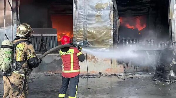 Сотрудники противопожарной службы во время тушения пожара в здании научно-производственного комплекса в Арамиле