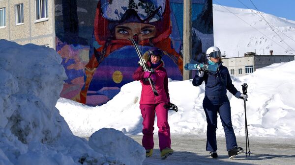 Лыжницы идут кататься на горных лыжах в Кировске