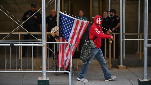 Мужчина с флагом США на Манхэттене в Нью-Йорке, США 
