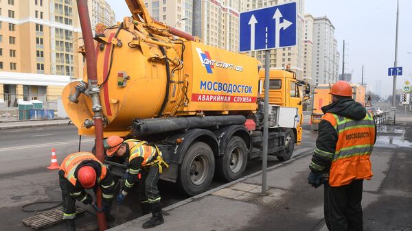 Сотрудники ГУП Мосводосток чистят коллектор на одной из улиц в Москве