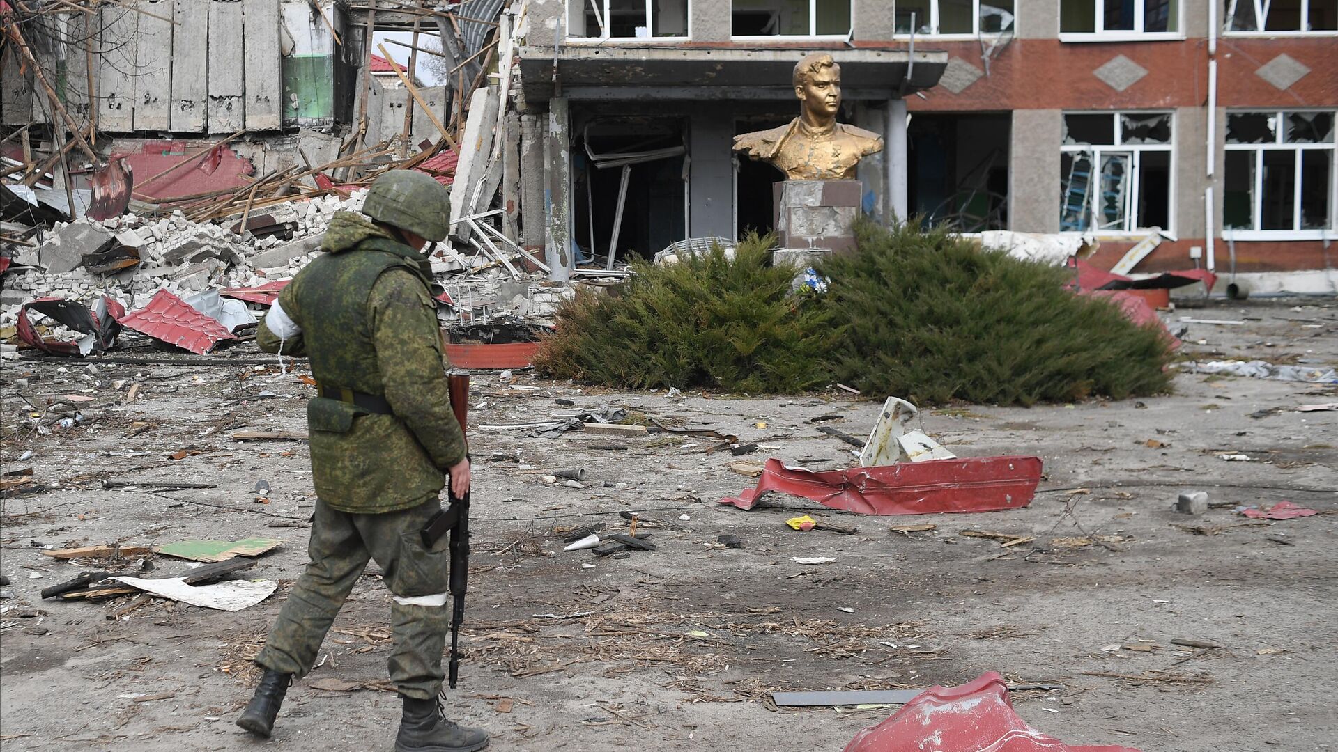 Военнослужащий у памятника герою Великой Отечественной войны Петру Шевченко у школы в поселке Смоляниново в ЛНР - РИА Новости, 1920, 25.03.2023