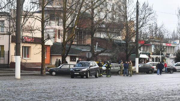 Спасатели и военнослужащие на одной из улиц, пострадавших в результате артиллерийского обстрела со стороны ВСУ в Мелитополе