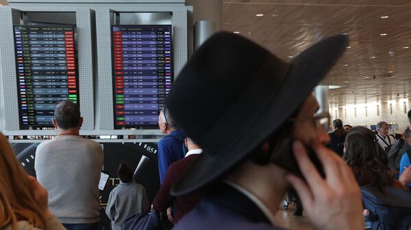 Пассажиры ждут своих рейсов во время забастовки в зале вылета в международном аэропорту Бен-Гурион недалеко от Тель-Авива