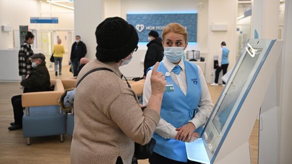 Пациентка у электронного терминала в поликлинике в Москве 