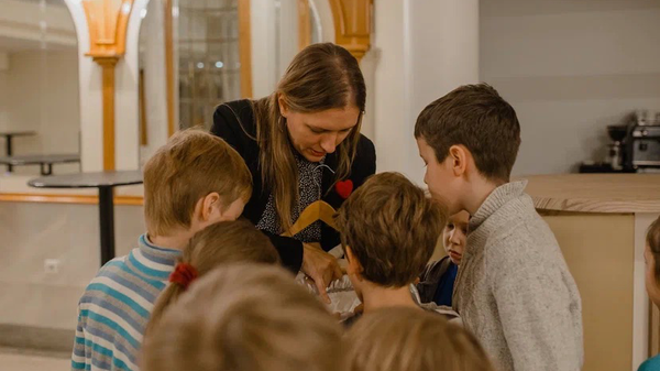 Руководитель образовательного кластера Новой Оперы ОКНО Алиса Спирина показывает детям театральные костюмы на экскурсии по театру
