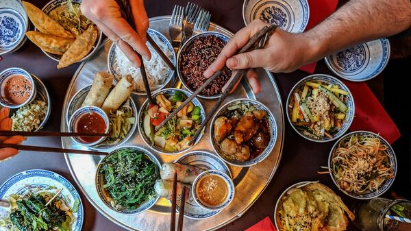 Люди едят блюда китайской кухни