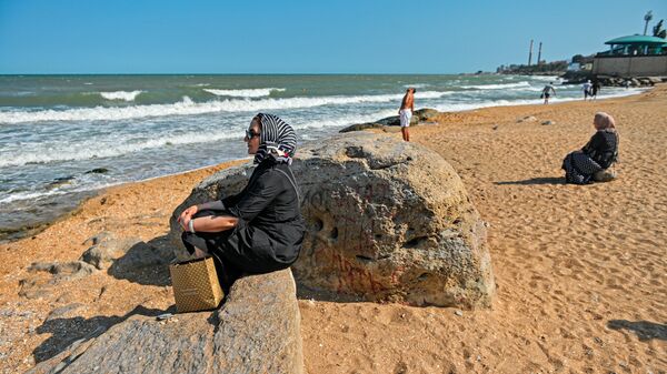 Отдыхающие на берегу Каспийского моря на городском пляже в Махачкале