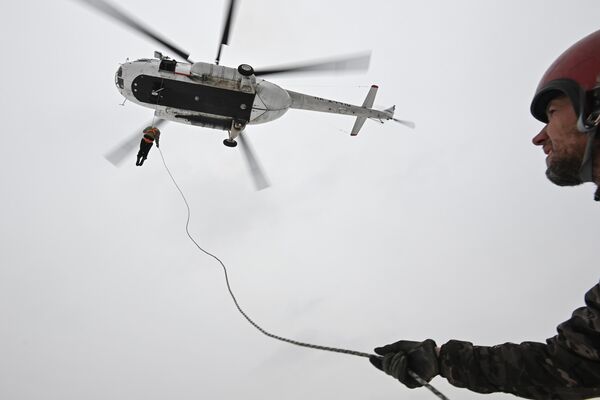 Участники основного состава пожарно-десантной службы ГАУ НСО Новосибирская база авиационной охраны лесов во время воздушной тренировки по десантированию с использованием спускового устройства с вертолета МИ-8 на вертолетной площадке возле села Барлак в Новосибирской области