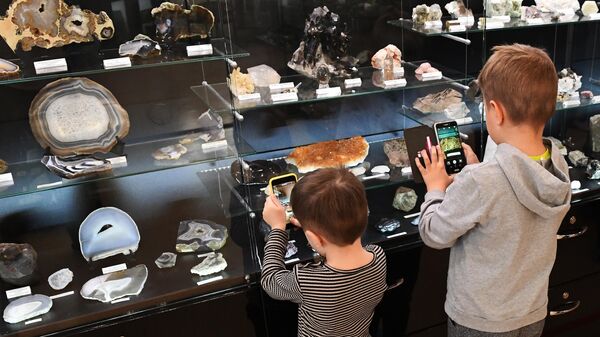 Юные посетители фотографируют экспонаты в Музее геологии Центральной Сибири GEOS в Красноярске.
